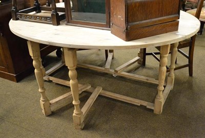 Lot 1219 - A large stripped pine farmhouse gateleg table, 168cm by 144cm by 73cm