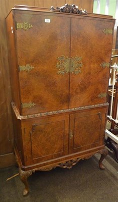 Lot 1230 - An early 20th century figured walnut veneered cocktail cabinet in Queen Anne style with...