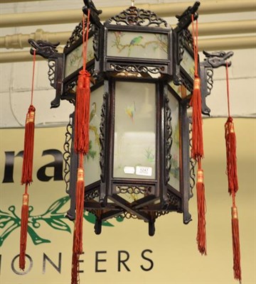 Lot 1247 - A Chinese hardwood fretwork hexagonal hanging lantern with painted glass panels and hanging tassels