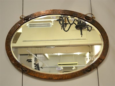 Lot 1252 - An Arts & Crafts oval planished copper wall mirror, 83cm by 58cm