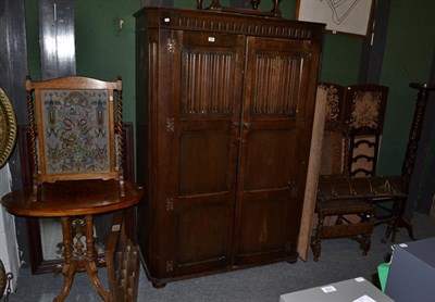Lot 1287 - A group of furniture comprising a 20th century oak linen-fold carved wardrobe, 126cm by 56cm by...