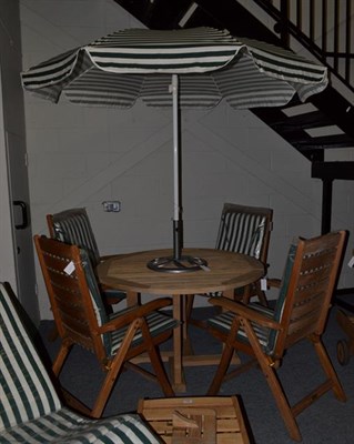 Lot 1300 - A slatted circular garden dining table, including four matching steamer chairs by TEAK TIGER...