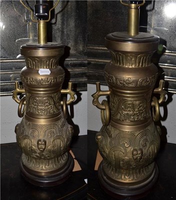 Lot 1333 - A pair of near Eastern brass lamps, of archaistic form