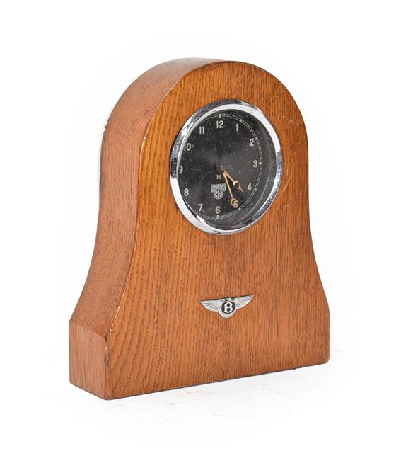 Lot 8 - A 1930's Smith's Car Clock, mounted in an oak case with Bentley winged badge emblem, 20cm high