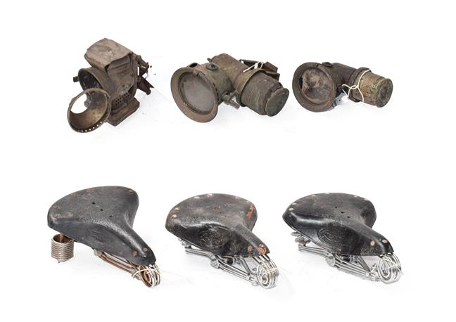 Lot 28 - ~ Three Early 20th Century Carbide Bicycle Lamps; and Three Vintage Leather Motorcycle Seats,...