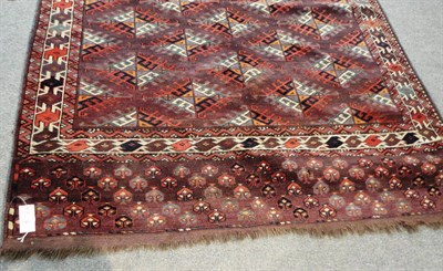 Lot 1469 - Yomut Carpet  West Turkestan The aubergine lattice field of hooked Dyrnak guls enclosed by...