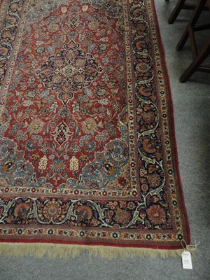 Lot 1476 - Kashan Rug  Central Persia The rust field of floral vines around an indigo medallion framed by...