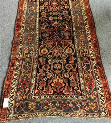 Lot 1497 - North West Persian Kurdish Runner The abrashed indigo field of Herati design enclosed by borders of