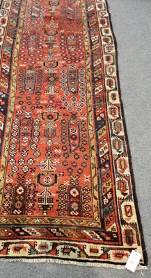 Lot 1503 - Narrow North West Persian Runner The madder field with columns of boteh and flowers enclosed by...