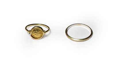 Lot 197 - A band ring, stamped '750', finger size S1/2; and a token ring, stamped '750', finger size L (a.f.)