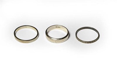 Lot 198 - Two band rings, stamped '750', finger sizes R and U1/2; and another band ring, stamped '800',...