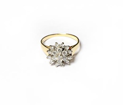 Lot 232 - An 18 carat gold diamond cluster ring, the central raised round brilliant cut diamond within a...