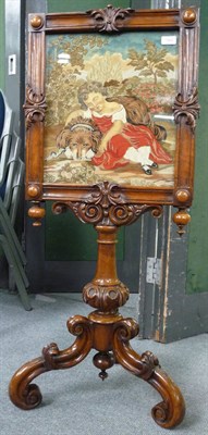 Lot 1542 - A Victorian Walnut Fire Screen, mid 19th century, with later needlework panel depicting a girl...