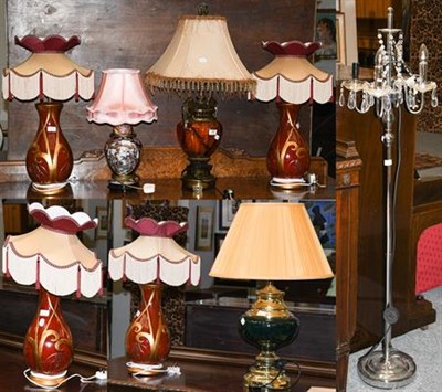 Lot 394 - A set of four red glazed baluster form pottery table lamps with silk shades, together with...