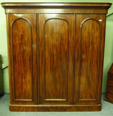 Lot 1554 - A Victorian Mahogany Triple Door Wardrobe, 3rd quarter 19th century, the bold cornice above a plain