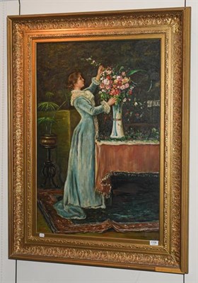 Lot 1106 - W Mander (Contemporary) A lady arranging flowers in an interior, signed oil on canvas, 90cm by 60cm