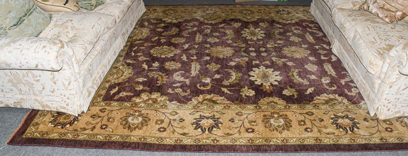 Lot 1200 - Large Indian carpet, the aubergine field with an all over design of large flower heads and...