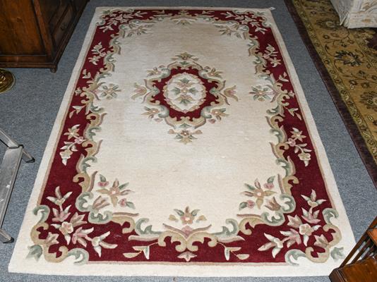 Lot 1201 - An Indian rug, the ivory field with floral medallion framed by borders 24cm by 152cm