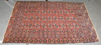 Lot 1209 - A Tekke rug, the madder field with three columns of quartered guls enclosed by stellar motif...