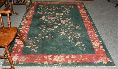 Lot 1211 - A Chinese rug, the emerald field of birds and flowering plants enclosed by floral borders, 268cm by