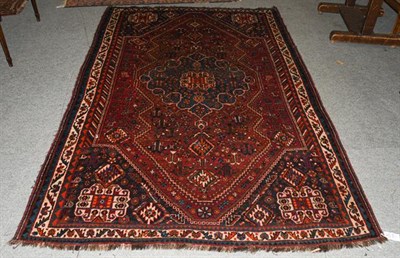 Lot 1214 - A Kashgai rug, the chestnut field with sky blue medallion framed by spandrels and ivory...