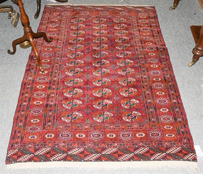 Lot 1217 - A Tekke rug, the blood red field with three colums of guls enclosed by stellar motif borders, 176cm