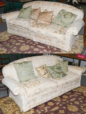 Lot 1223 - A pair of feather-filled three-seater sofas, modern, covered in floral cream fabric with...