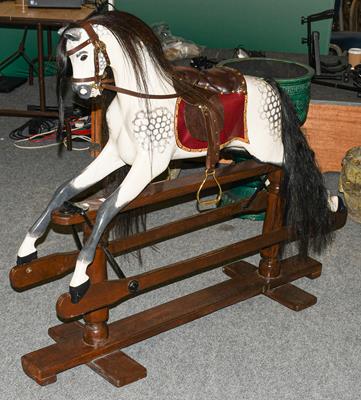 Lot 1226 - A dapple grey painted rocking horse on trestle base, one bracket stamped G&J L Ltd, 135cm long...