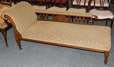 Lot 1328 - A late Victorian carved oak chaise longue, circa 1890, recovered in acanthus scrolled fabric,...