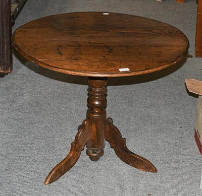 Lot 1372 - A George III oak tilt top tripod table with bird cage mechanism, 75cm diameter by 62cm