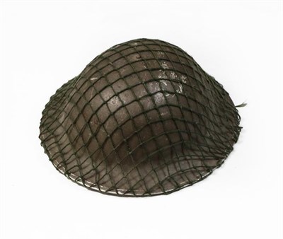 Lot 76 - A Second World War British Brodie Helmet, with original green finish, camouflage netting, liner...