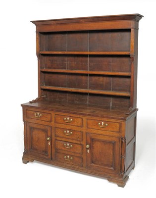 Lot 1606 - A George III Oak Enclosed Dresser and Rack, with three fixed shelves above an arrangement of...