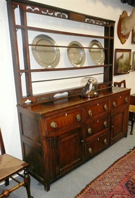 Lot 1608 - An 18th Century Oak and Mahogany Crossbanded Enclosed Dresser and Rack, the fret cut pierced frieze