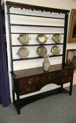 Lot 1609 - An 18th Century Open Dresser and Rack, with wavy shaped frieze and shelves with iron cup hooks, the