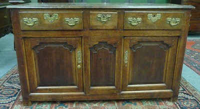 Lot 1610 - An 18th Century Oak Dresser Base, with three frieze drawers above three fielded panels, two as...