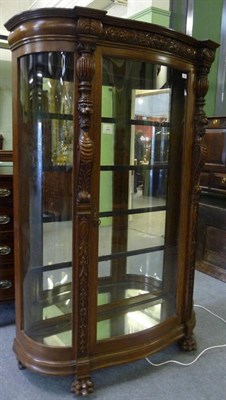 Lot 1621 - A Carved Oak Vitrine, early 20th century, of bowfront form with carved frieze centred by a...