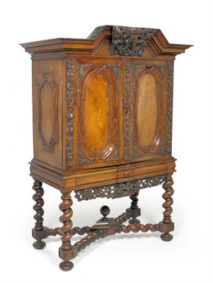 Lot 1624 - An 18th Century German Walnut Cabinet on Stand, the bold pediment above floral and leaf carved...