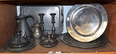 Lot 164 - A quantity of pewter comprising chargers, jug, candlesticks, tray, etc (one shelf)