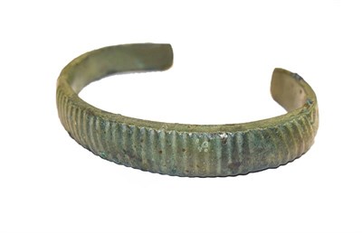 Lot 194 - A Roman bronze torque bangle with reeded decoration, 8cm wide