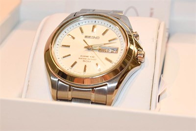 Lot 233 - A stainless steel kinetic day/date wristwatch, signed Seiko, with boxes and booklets, watch...
