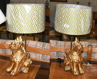 Lot 372 - A pair of gilt wood temple dragon table lamps with shades, 32cm high (without shades)