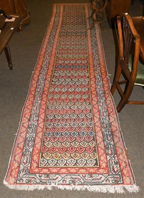 Lot 1002 - A West Persian village runner, the chocolate brown field with rows of polychrome boteh enclosed...