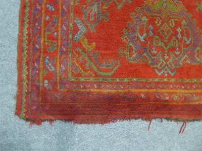 Lot 1011 - An Ushak Rug, the tomato red field with three medallions enclosed by multiple narrow borders, 245cm