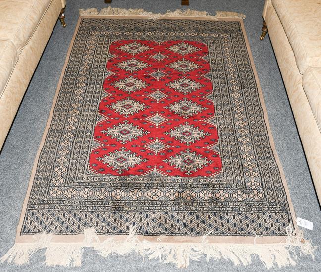 Lot 1012 - A Kashmir Bukhara rug, the crimson field with two rows of güls enclosed by multiple borders, 179cm