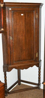 Lot 1147 - A George III panelled oak corner cupboard on stand, 90cm by 55cm by 189cm