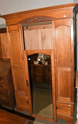 Lot 1157 - An Edwardian oak mirror front single door wardrobe, 130cm by 46cm by 208cm