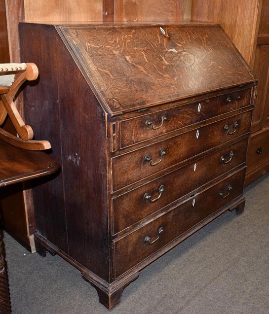 Lot 1158 - A George III crossbanded and inlaid oak bureau with fully fitted interior