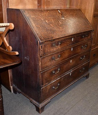 Lot 1158 - A George III crossbanded and inlaid oak bureau with fully fitted interior
