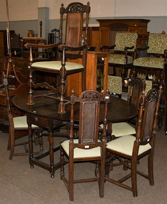 Lot 1169 - An oak gateleg table, 177cm by 130cm by 77cm, together with a set of six high back caned chairs...