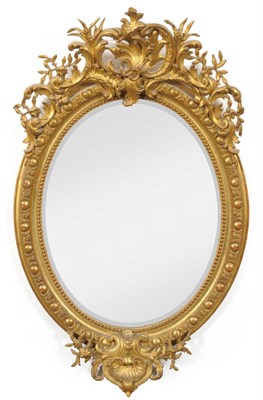 Lot 1673 - An Early Victorian Gilt and Gesso Oval Wall Mirror, mid 19th century, the rococo style frame with a